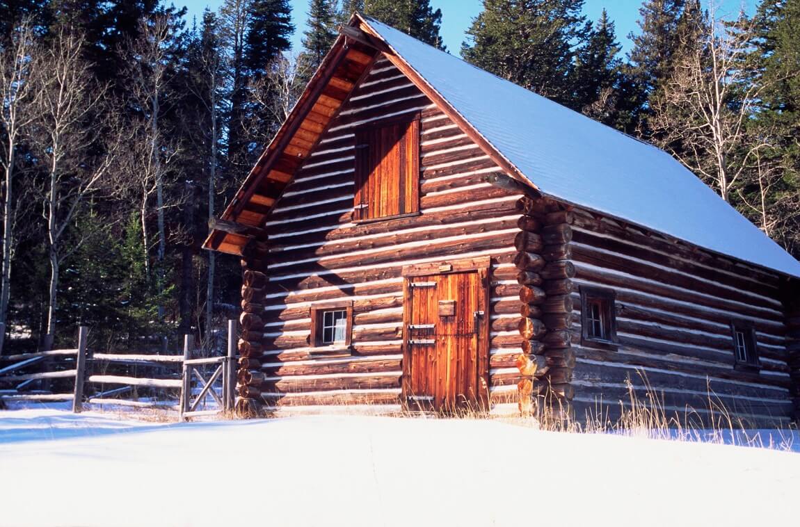 dom z bali drewnianej w lesie zimą